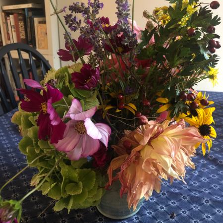 A vase filled with different coloured flowers